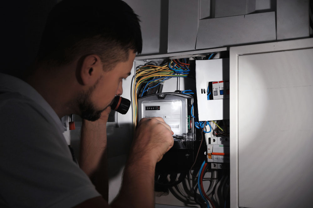 homeowner holding a flashlight (looking at electrical wiring)